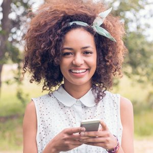 happy-young-woman-using-smartphone-on-a-sunny-day-P8PX76C.jpg